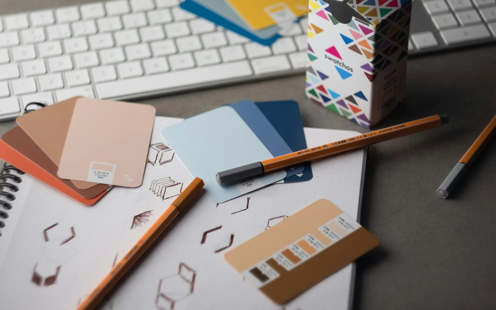 Grafikdesign-Schreibtisch mit Farbmustern zur Erklärung druckfertiger Grafiken
