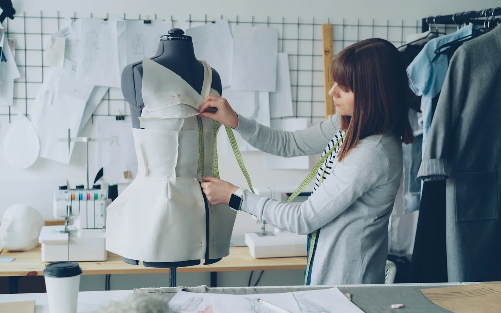 Modedesigner misst ein Kleidungsstück, um genaue Druckabmessungen und -platzierung zu demonstrieren